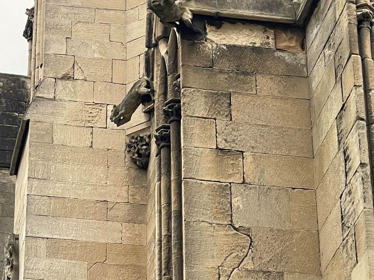 A stone building with gargoyles on the side
Description automatically generated